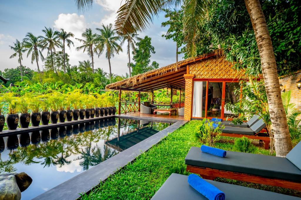 暹粒Authentic Khmer Village Resort的棕榈树旁的房屋