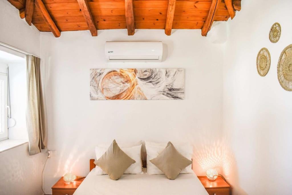 斯基亚索斯镇HUT HOUSE Εξοχικό στην παραλία Μ. Άμμος的一间卧室配有带白色床单和枕头的床。