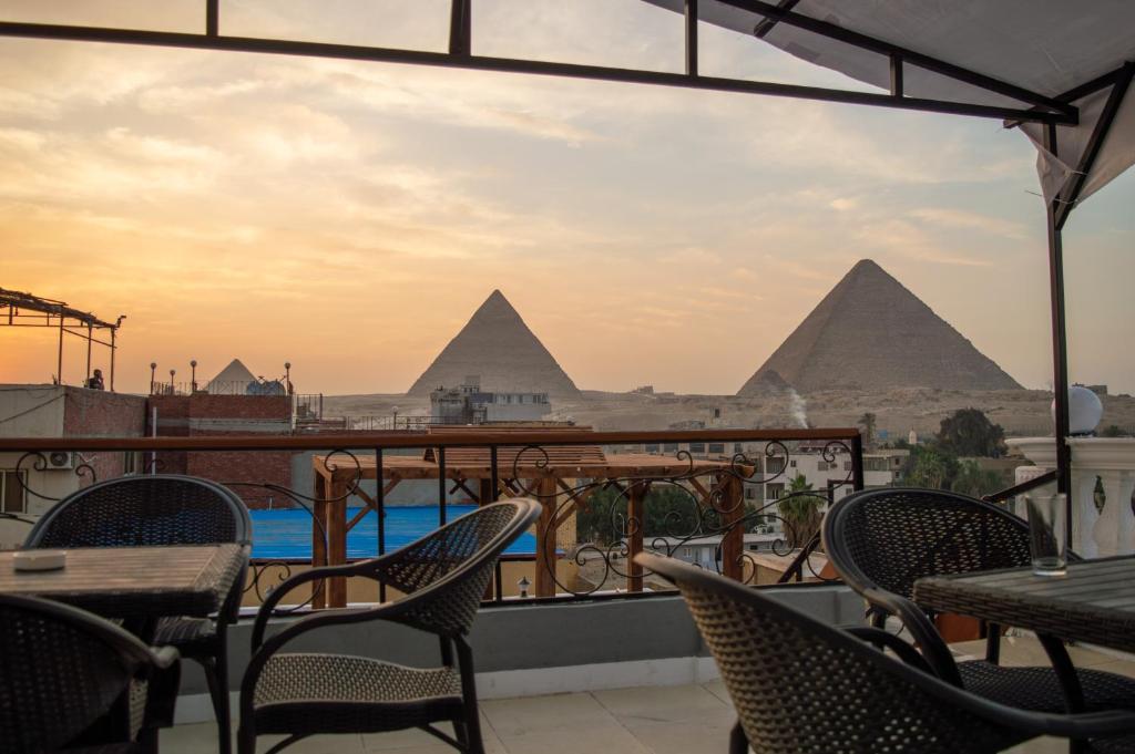 开罗Pyramids Gate Hotel的从餐厅的阳台上可欣赏到金字塔的景色