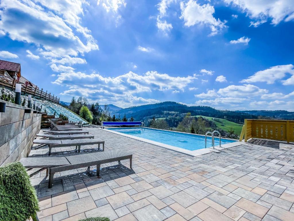 维斯瓦卡罗洛多尔酒店的一个带长椅的游泳池,享有山脉美景