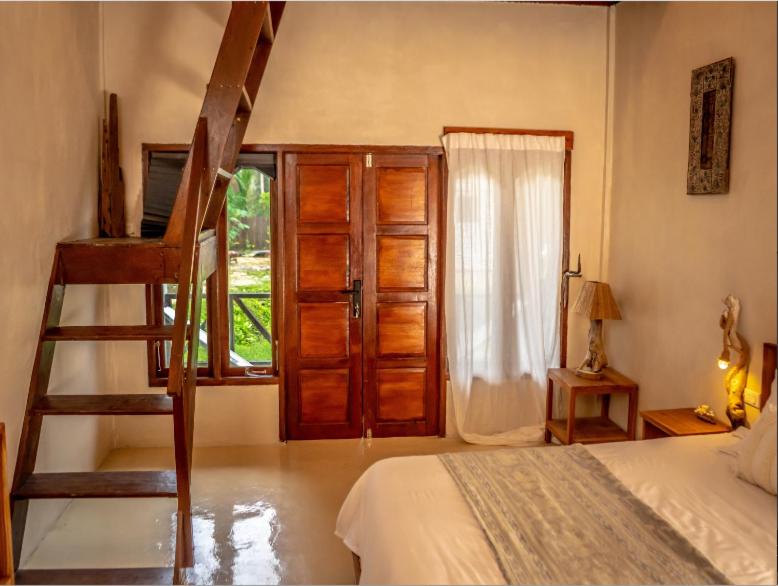 LasikinDylan’s Retreat的一间卧室设有梯子、一张床和一个窗户