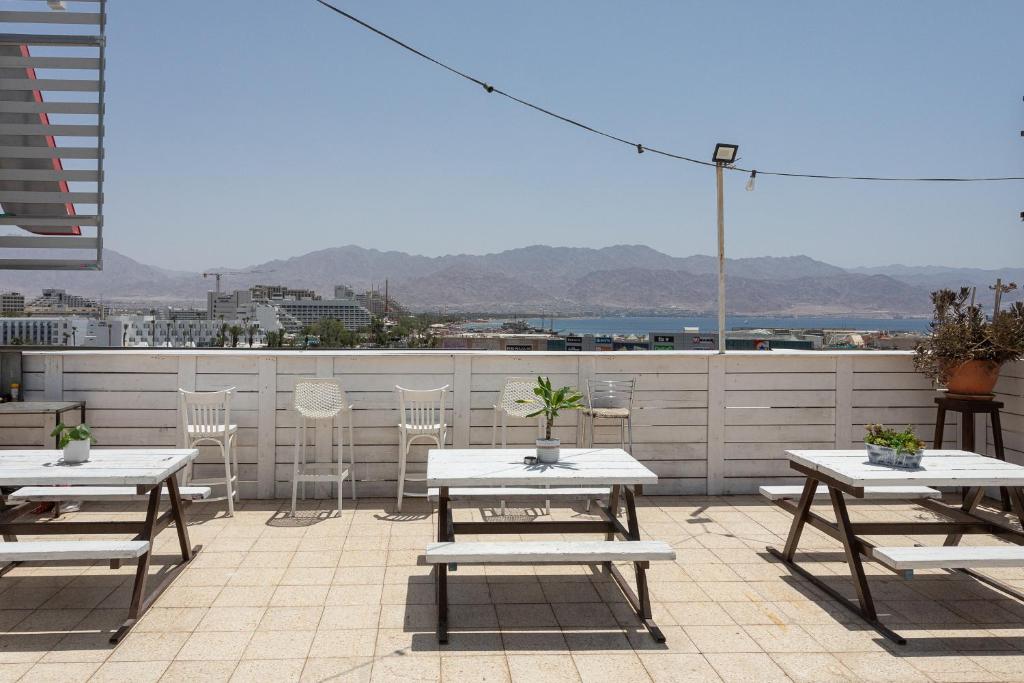 埃拉特Little Prince Hostel-5 Min Walk To The Beach的屋顶上带桌椅的天井