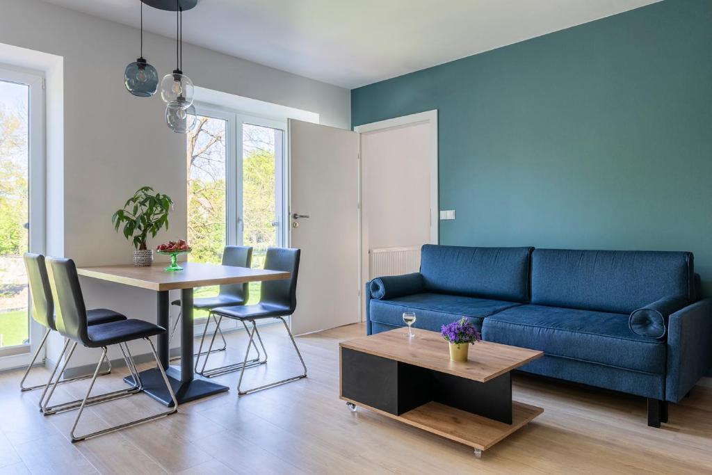 杜什尼基-兹德鲁伊APARTAMENTY ZDROJOWA 9的客厅配有蓝色的沙发和桌子
