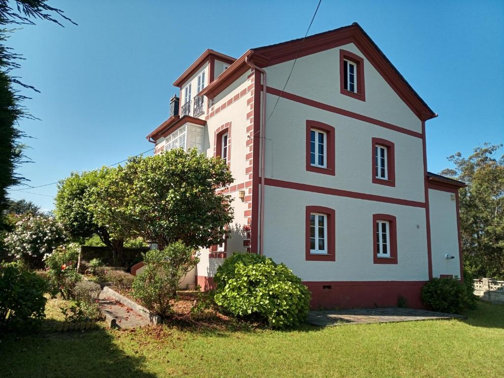 奥尔蒂盖拉Casa Tula的一座大白色房子,在院子里装饰着红色的饰物