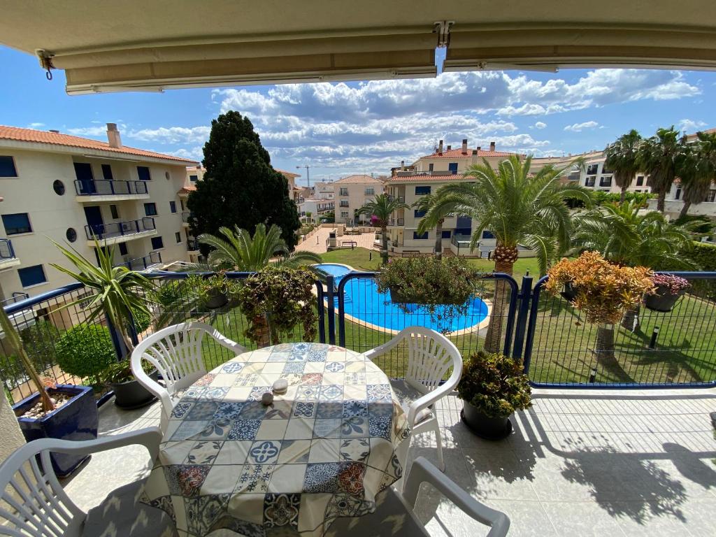 阿尔考斯布里Apartamentos Porta Mediterranea Altamar的一个带桌椅的阳台和一个游泳池