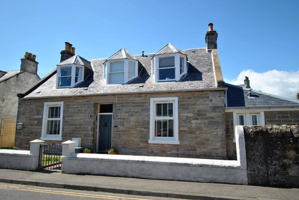 安斯特拉瑟Shore Cottage Anstruther- stylish home by the sea的街上的砖房,有白色的窗户