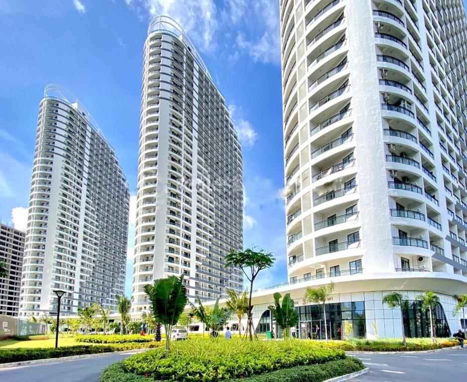西哈努克Apartments in Star Bay with sea view的两座高大的建筑,在街道前有棕榈树