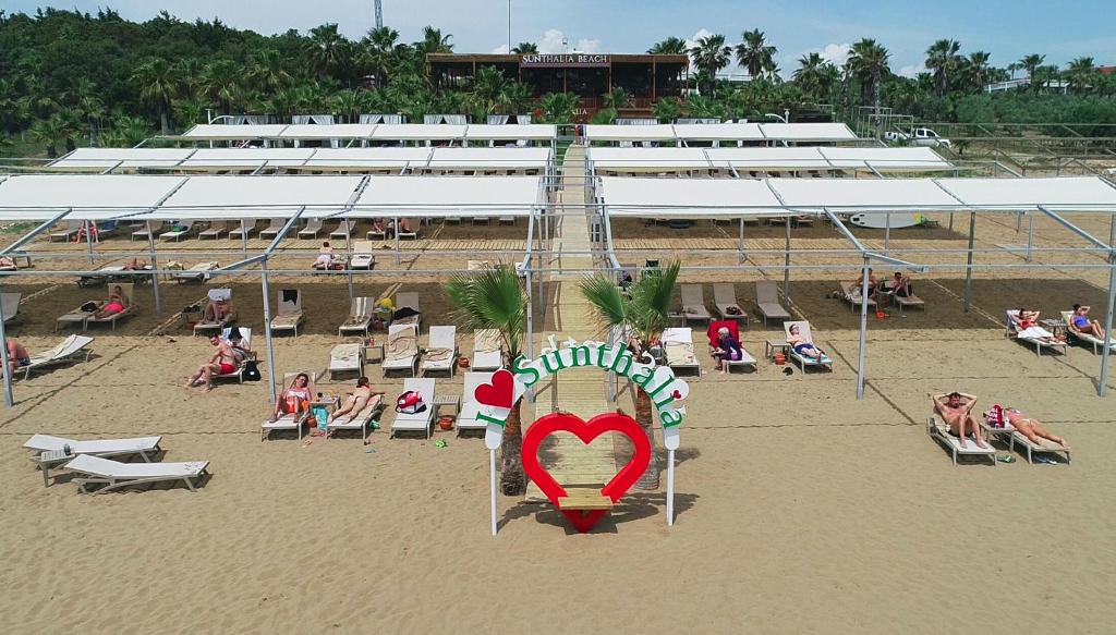 锡德Sunthalia Hotels & Resorts Ultra All Inclusive Adults Only Party Hotel的一群人坐在海滩上