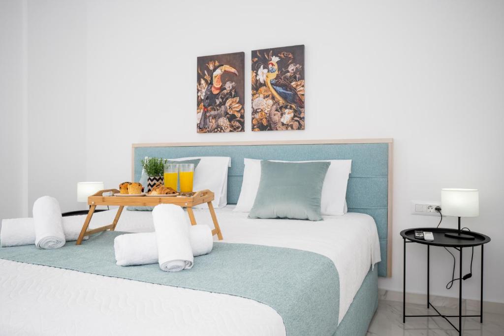赫索尼索斯Athinais Suites的一间卧室配有一张大床和蓝色床头板