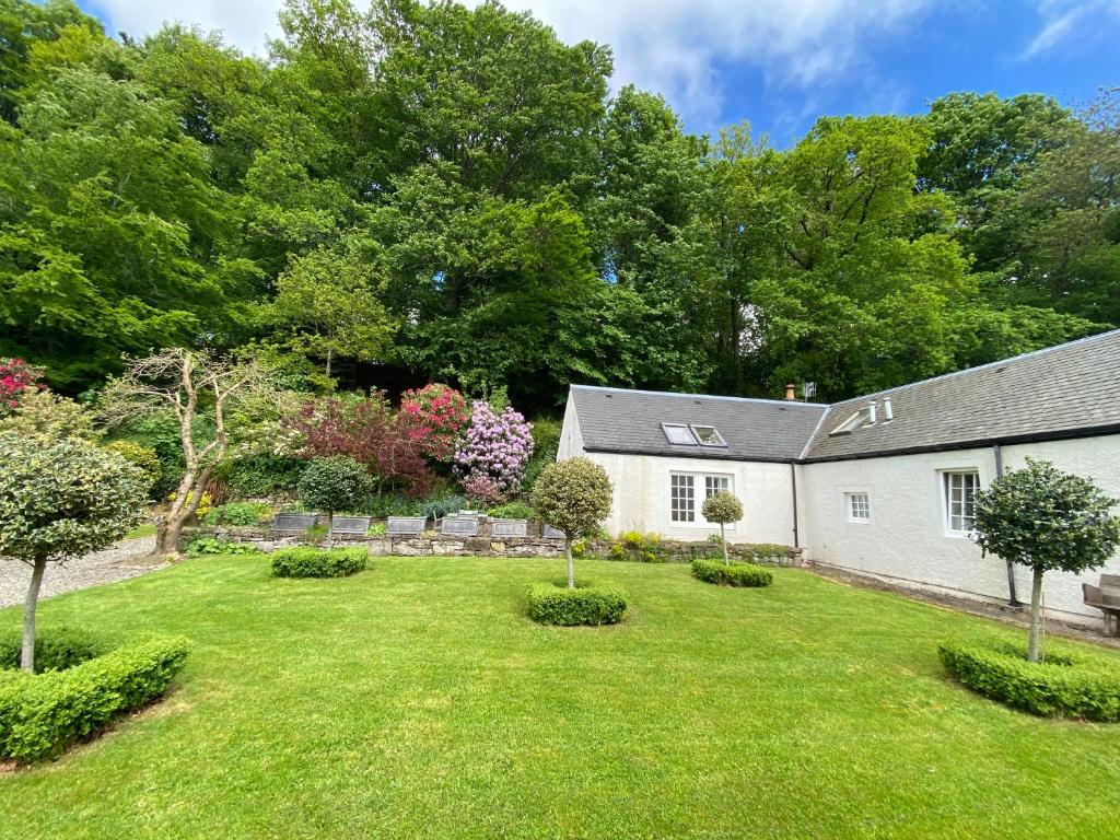 克里夫Spacious cottage - walk to Crieff的一座带白色房子和树木的院子