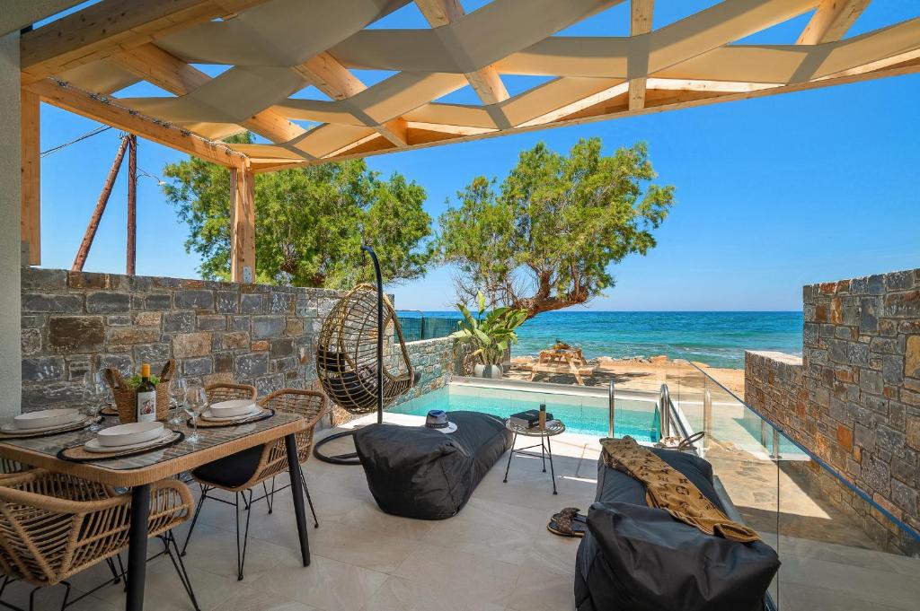 莫拉托斯Milatos Seaside Suites的一个带桌椅的庭院和一个游泳池