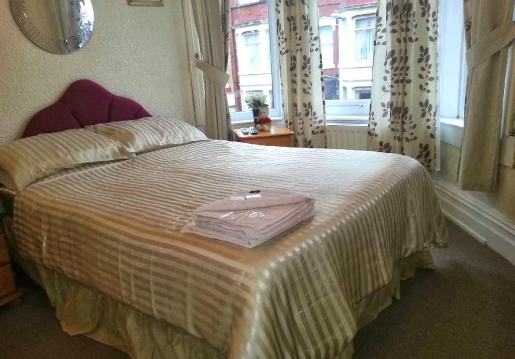 布莱克浦Lynwood Hotel & Spa的一间卧室,配有一张带粉红色袋的床