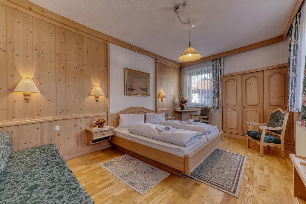 博登迈斯Hotel Bayerischer Hof的一间带一张大床的卧室,位于带木墙的房间