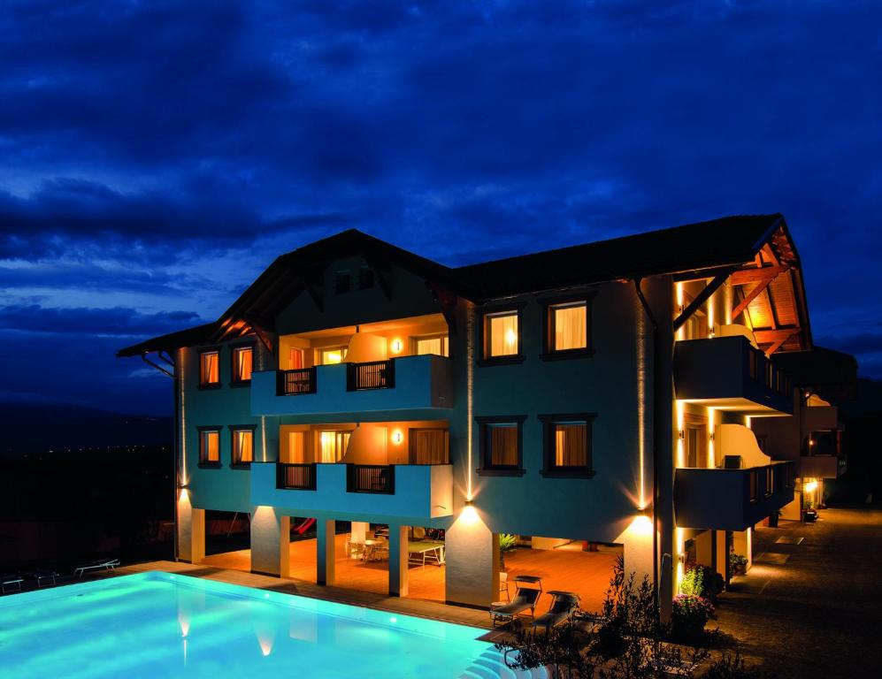 卡尔达罗Garni Hotel Peterlinhof的夜间带游泳池的别墅