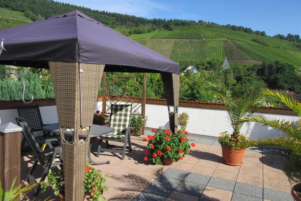 萨尔堡Ferienwohnung Wilhelmi的庭院配有遮阳伞和桌椅。