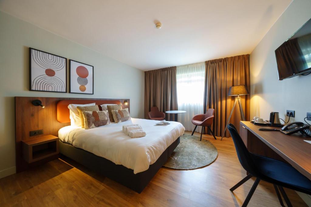 迪南莫里尼花园酒店的配有一张床和一张书桌的酒店客房