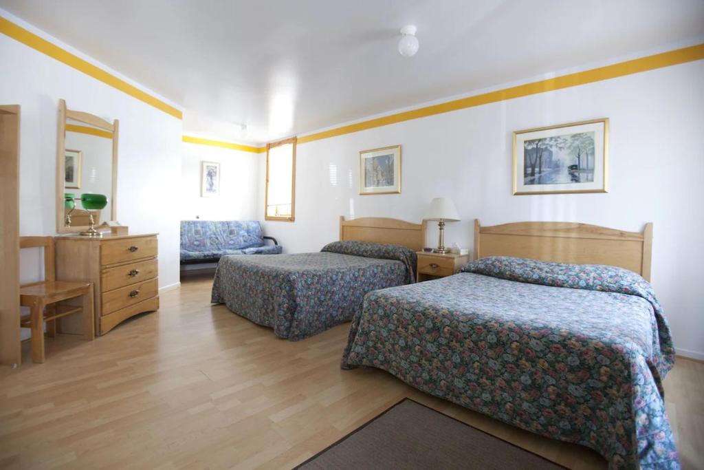 泰道沙克Hotel - Motel Georges的酒店客房,配有两张床和椅子