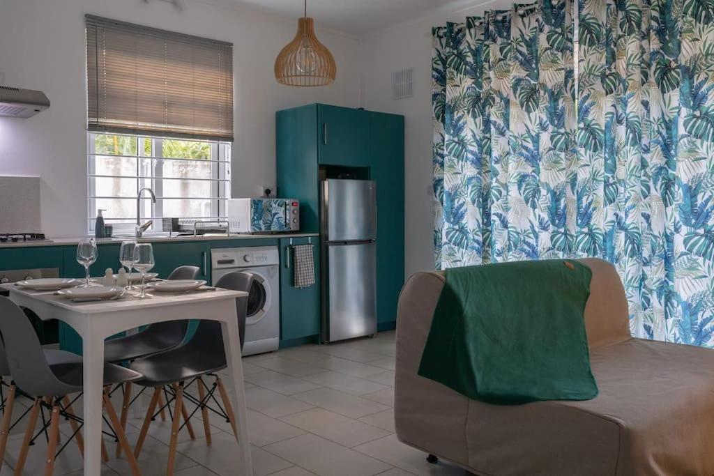 Coteau RaffinLe Rivage Appartement Mauritius的一间带桌子的厨房和一间带冰箱的厨房