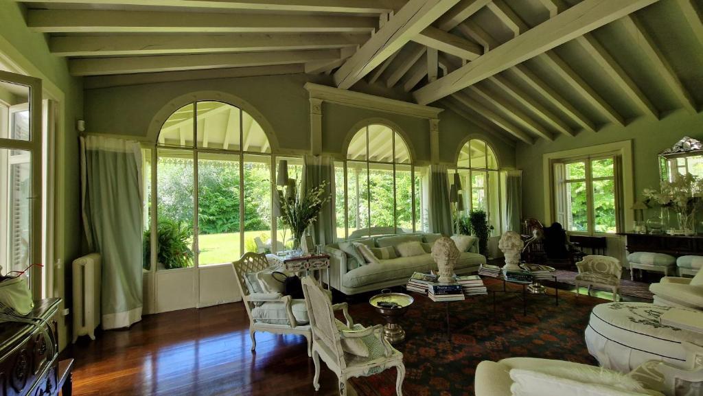 宏达瑞比亚Caserta的客厅配有许多家具和窗户。