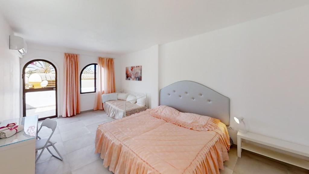 马斯帕洛马斯Villa las Buganvillas MASPALOMAS - Cocina y habitaciones con baños privados的一间卧室配有一张床、一把椅子和一张书桌