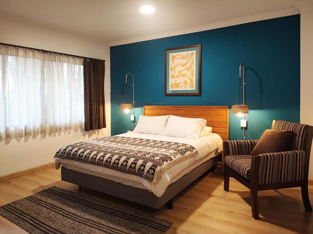 昆卡Hotel Casa Merced的一间卧室配有一张床和一把椅子
