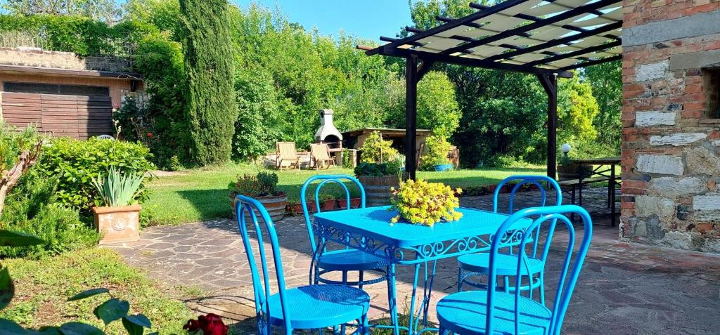 卡斯德尔诺沃贝拉登卡Chiantishire Lovely Cottage with Garden & Parking!的凉棚下的蓝色桌子和椅子