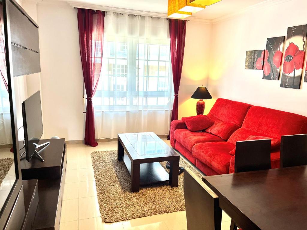 艾利亚德亚罗萨Apartamento Praia Naval的客厅配有红色的沙发和桌子