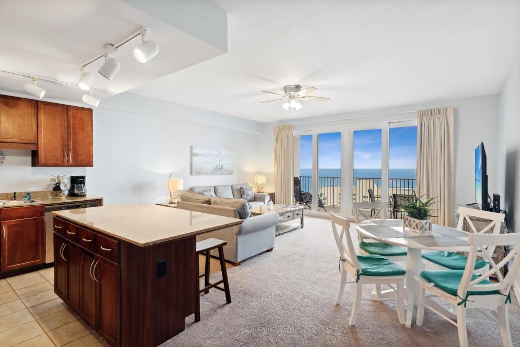 巴拿马城海滩Spacious Resort Condo with Breathtaking Gulf Views! by Dolce Vita Getaways PCB的厨房以及带桌椅的起居室。