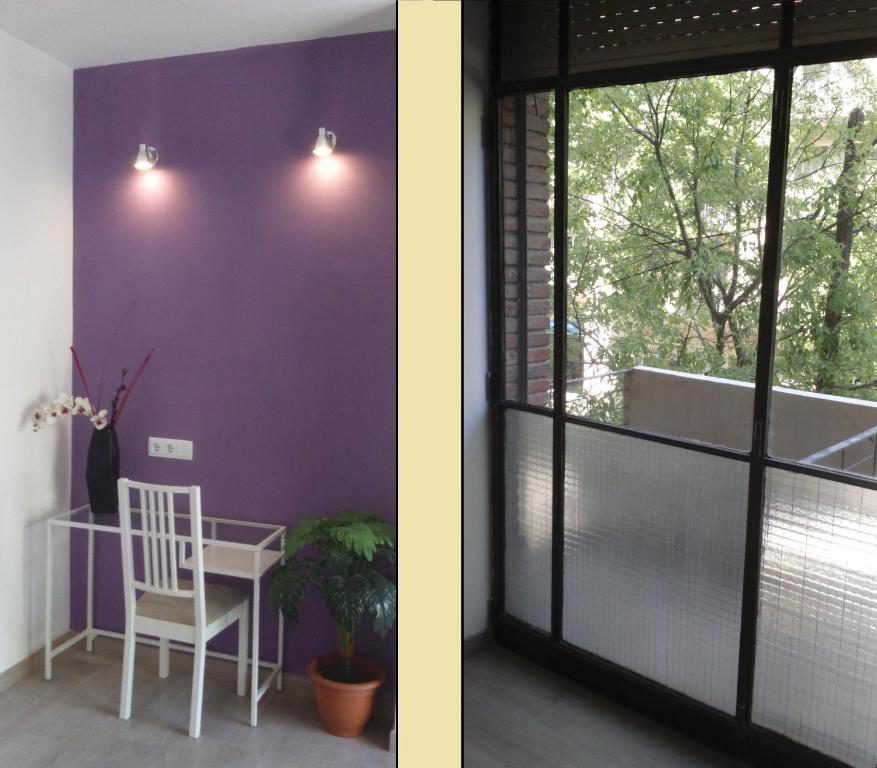 巴塞罗那布鲁斯达圣家堂旅馆的一间设有紫色墙壁、椅子和窗户的客房