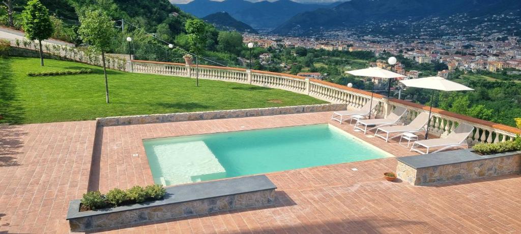 卡瓦德蒂雷尼Villa Marina的一个带两把椅子和一张桌子的游泳池以及一座小山