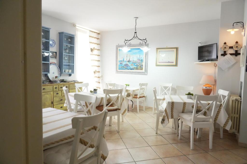 焦亚德尔科莱B&B Il Grifone的用餐室配有白色的桌子和白色的椅子