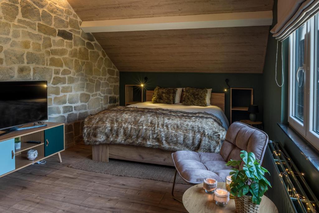斯帕Le Spalace的一间卧室设有一张床和石墙