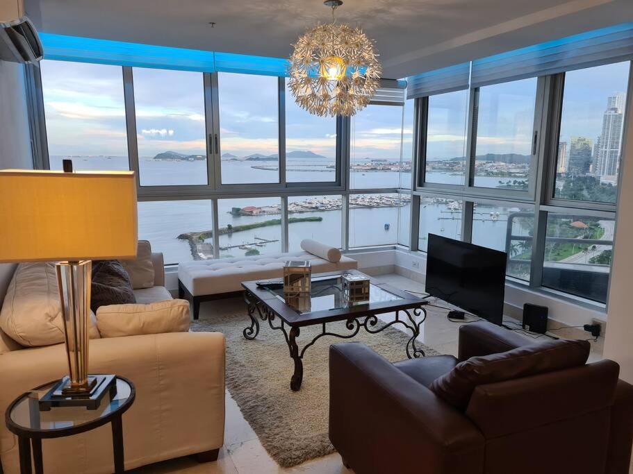 巴拿马城Amplio y hermoso apartamento frente a la bahía.的一间带吊灯并享有水景的客厅