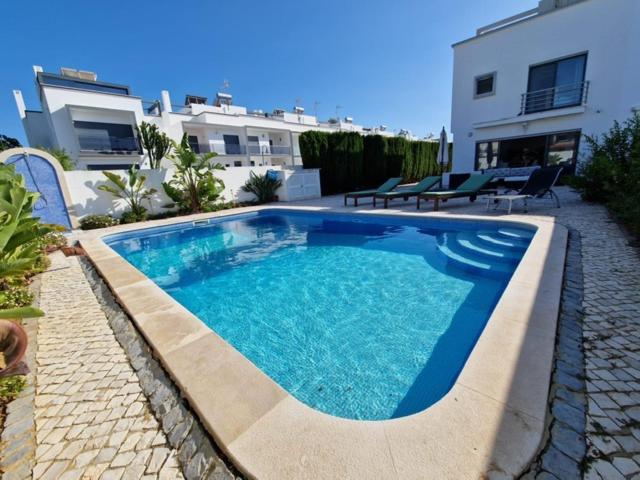 维拉诺瓦德卡塞拉Beachfront house,Manta Rota,Algarve的庭院里的一个蓝色海水游泳池