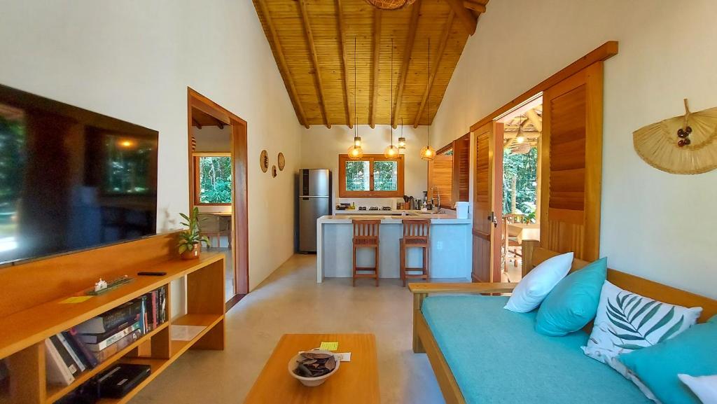 托兰克索Vila dos Macacos Trancoso的一间带蓝色沙发的客厅和一间厨房