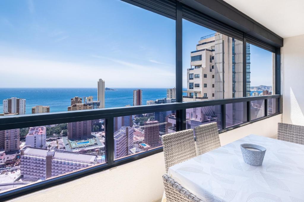 贝尼多姆Gemelos 26 Resort Apartment 27C Levante Beach的阳台配有桌子,享有海景。