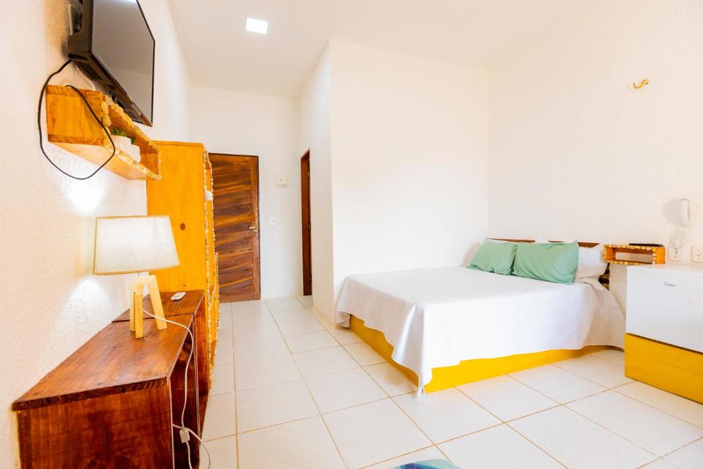 巴纳伊巴OYO Hotel Das Pedras的一间卧室配有一张床,墙上配有电视