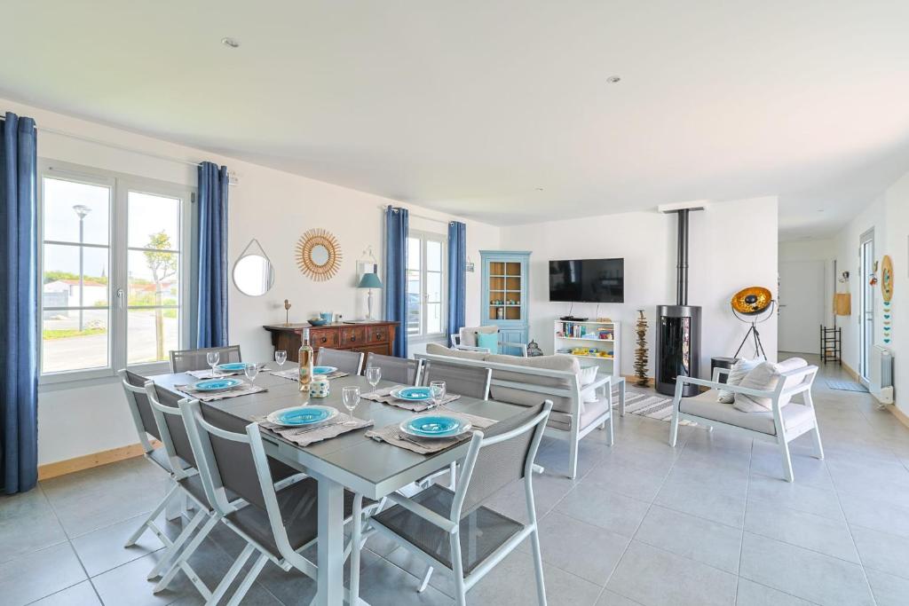 奥雷龙圣但尼Magnificent Villa recent quiet St Denis D'Oléron的用餐室以及带桌椅的起居室。