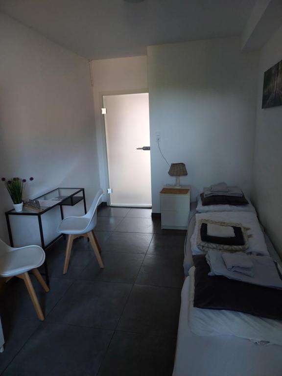 KürtenSnow White的一间卧室设有两张床、一张桌子和一扇门