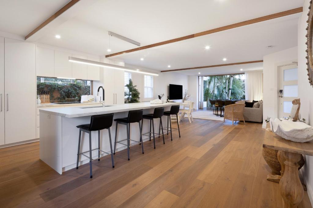 悉尼Beach Retreat的厨房以及带吧台和凳子的客厅。