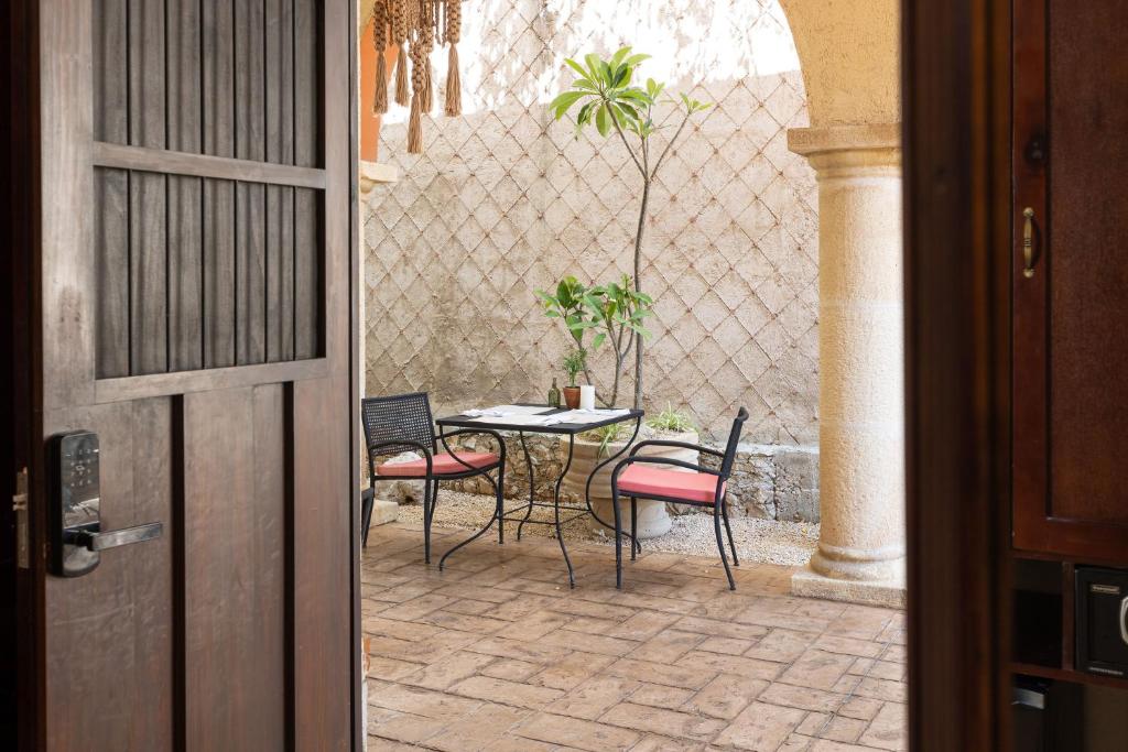 梅里达Casa Dos Lirios Hotel Boutique的庭院内带桌椅的庭院。