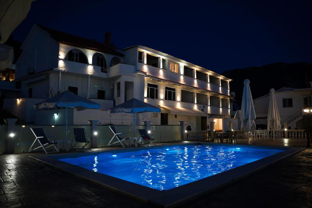 阿齐欧斯·贡多斯Kostas Beach Apartments的一家在晚上设有大型游泳池的酒店