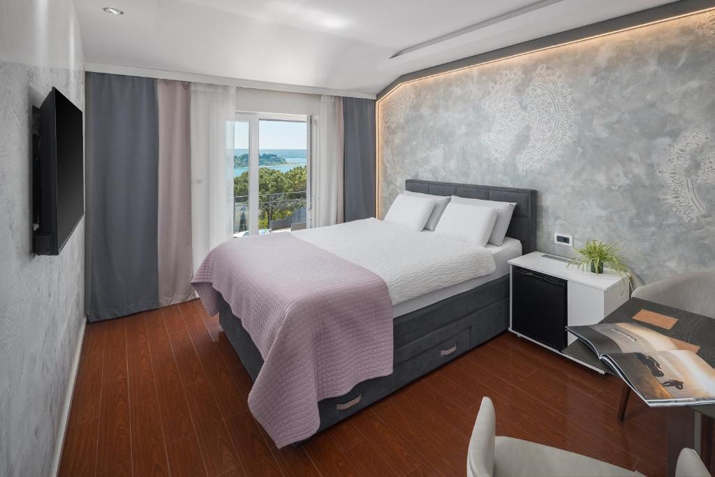 波尔托罗托米酒店的一间卧室设有一张大床和一个窗户。