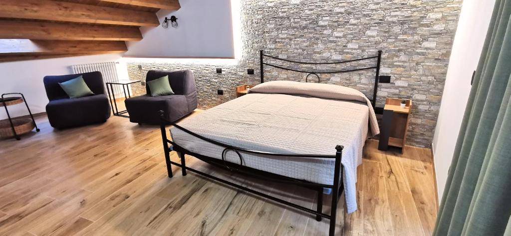 CasoliDietro le mura的一间卧室设有一张床和砖墙