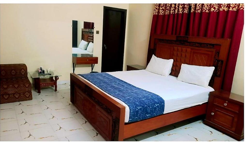 卡拉奇Hotel Sky Inn Gulsan的一间卧室配有一张大床和红色窗帘