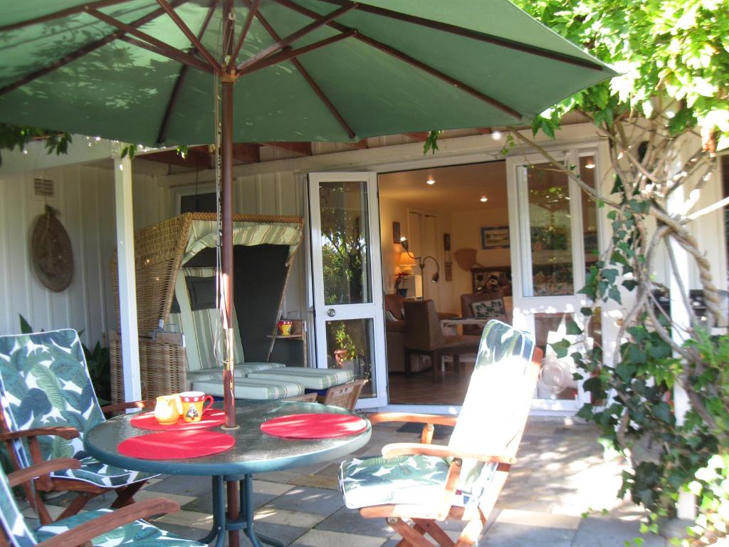 拉塞尔Aimeo Cottage的露台上的一张带绿伞的桌子