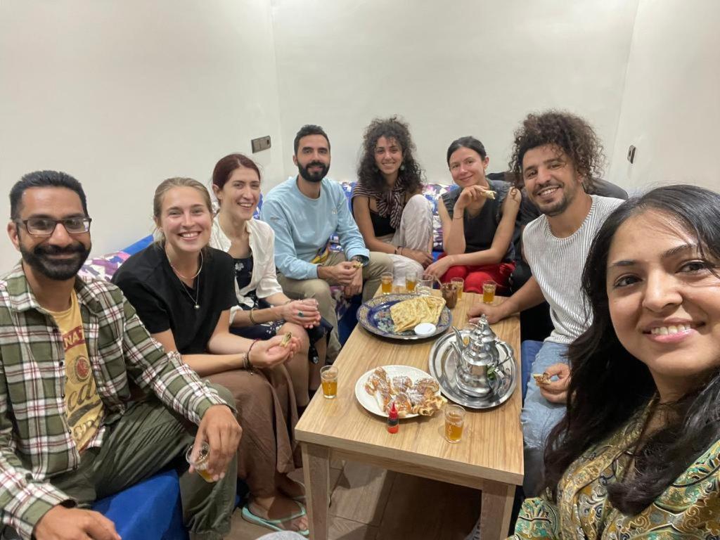阿加迪尔Moroccan Family House的一群人坐在桌子旁吃着食物