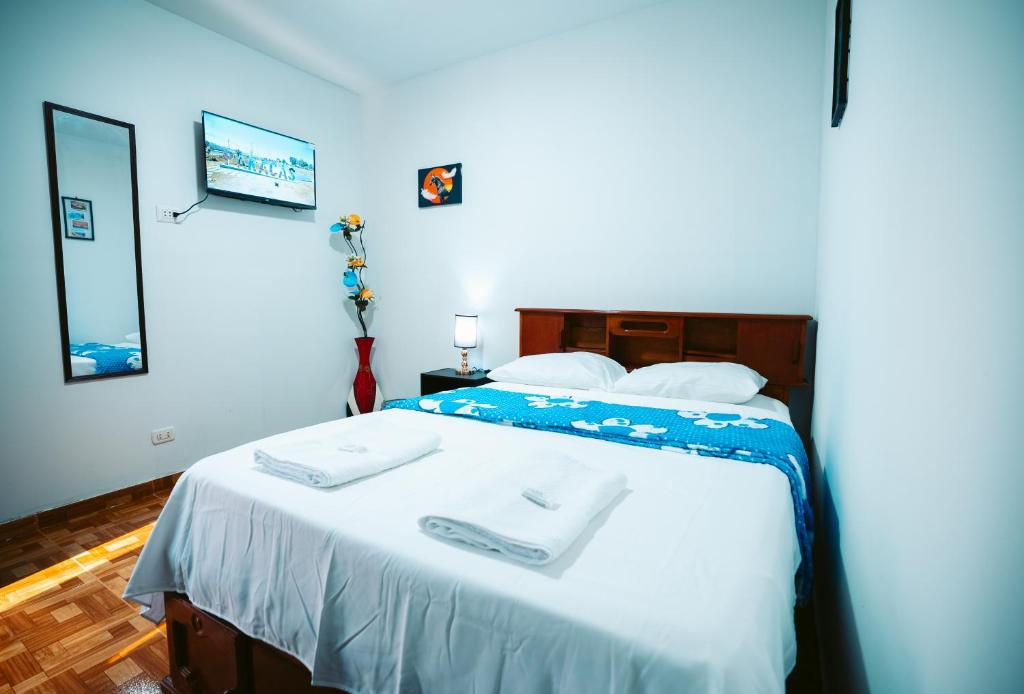帕拉卡斯POSADA MIS 3 BENDICIONES的一间卧室配有一张床,上面有两条毛巾