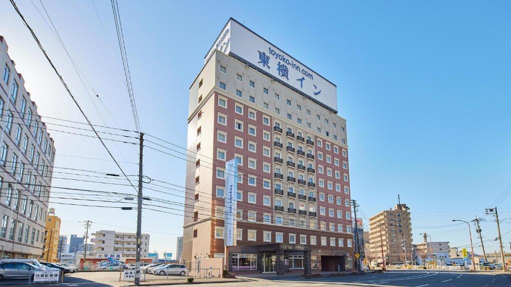 山口Toyoko Inn Shin-yamaguchi-eki Shinkansen-guchi的一座高大的建筑,上面有钟