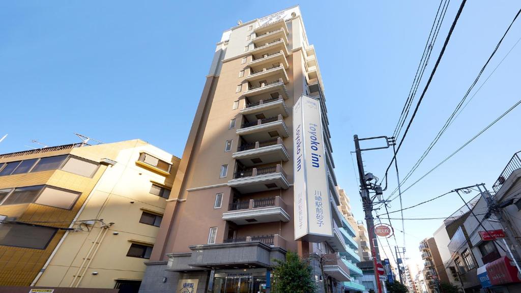川崎Toyoko Inn Kawasaki Ekimae Isago的前面有标志的高楼